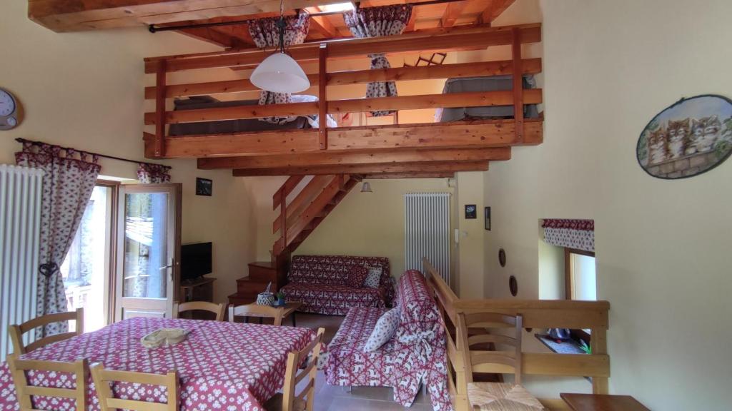 jadalnia ze stołem i krzesłami oraz drewnianym sufitem w obiekcie Casa Vacanze: Maison Des Gnomes w mieście Challand Saint Anselme