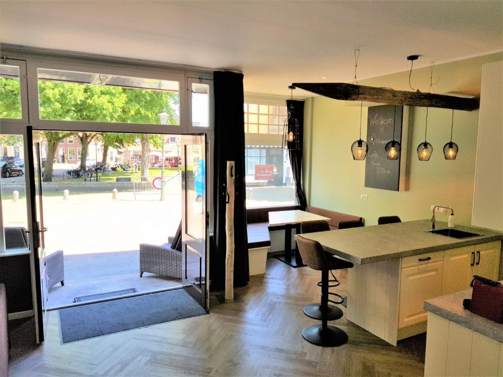 une cuisine avec une table et une porte donnant sur une terrasse. dans l'établissement Appartement "Hartje Haamstede", à Burgh-Haamstede