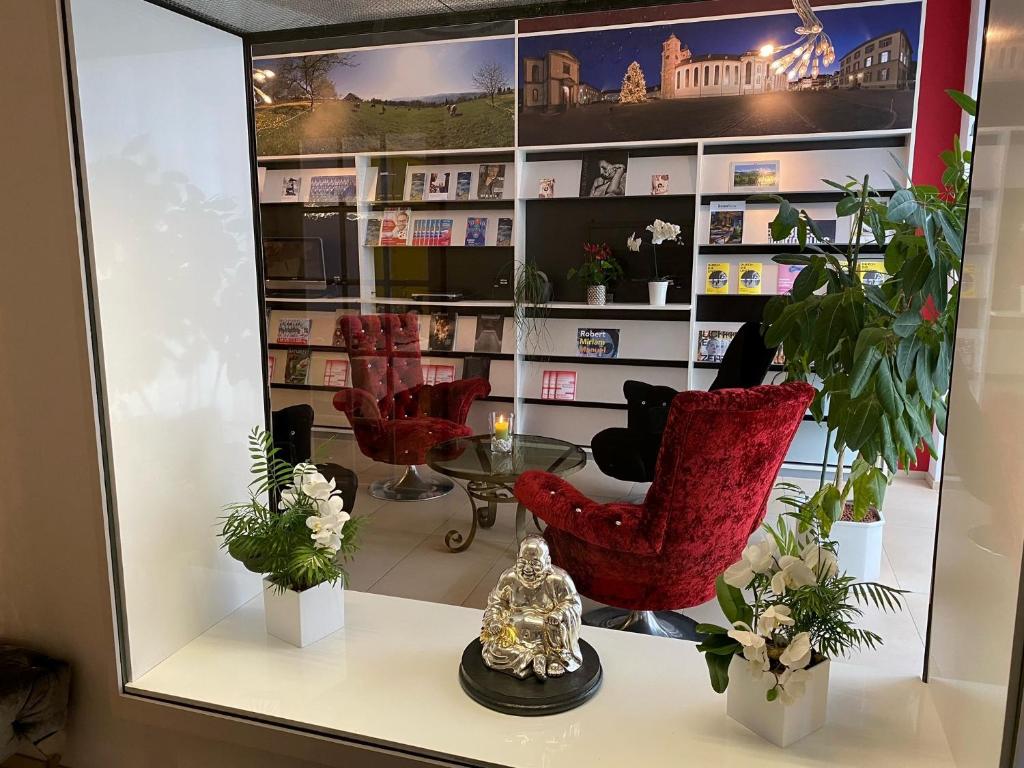 a mirror in a shop with red chairs and plants at Boutique City Hotel Gallo in St. Gallen