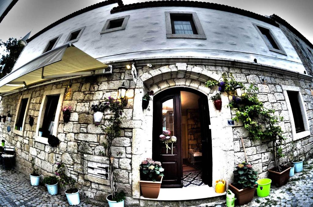 a stone building with plants and flowers on it at Alacati Zeynep in Alaçatı