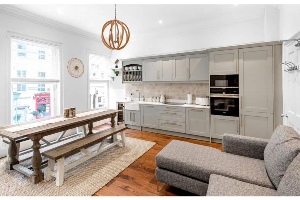 Argyle - Stunning 5 bed Luxury Home - Pulteney Bridge, Bath في باث: مطبخ مع دواليب بيضاء وطاولة وأريكة