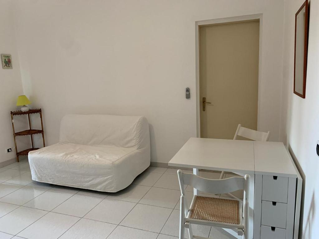 Cette chambre blanche comprend un lit et une chaise. dans l'établissement Portorosa, à Torre Forte