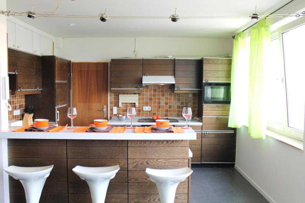 a kitchen with a counter with two wine glasses at RENTApartment Düsseldorf in Düsseldorf