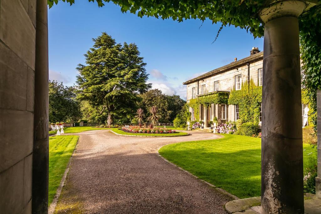a driveway leading to a house with a garden at Doxford Hall Hotel And Spa in Chathill