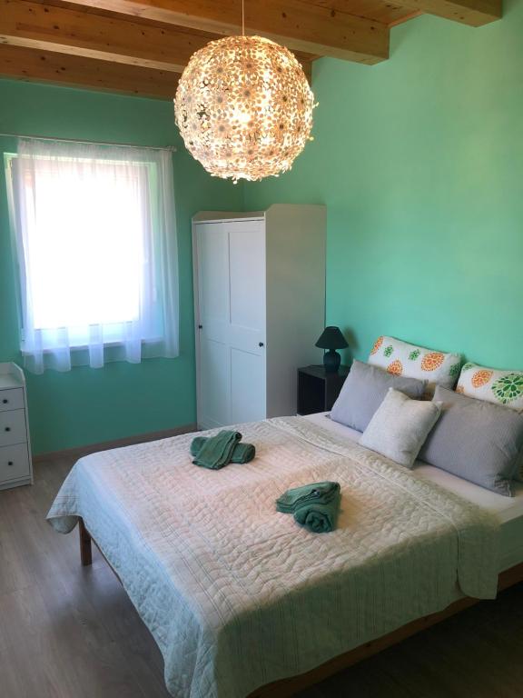 sypialnia z dużym łóżkiem z 2 zielonymi ręcznikami w obiekcie Szárszószép Villa w mieście Balatonszárszó