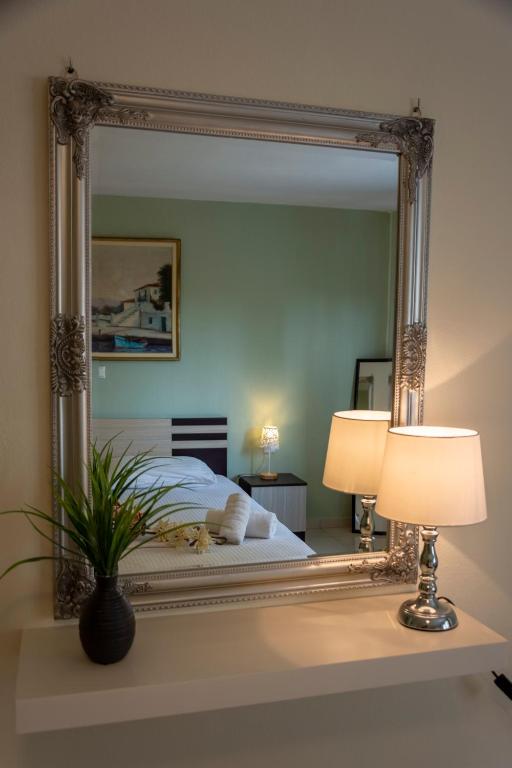 een spiegel op een tafel met een bed in een slaapkamer bij Irini Apartments in Kavala