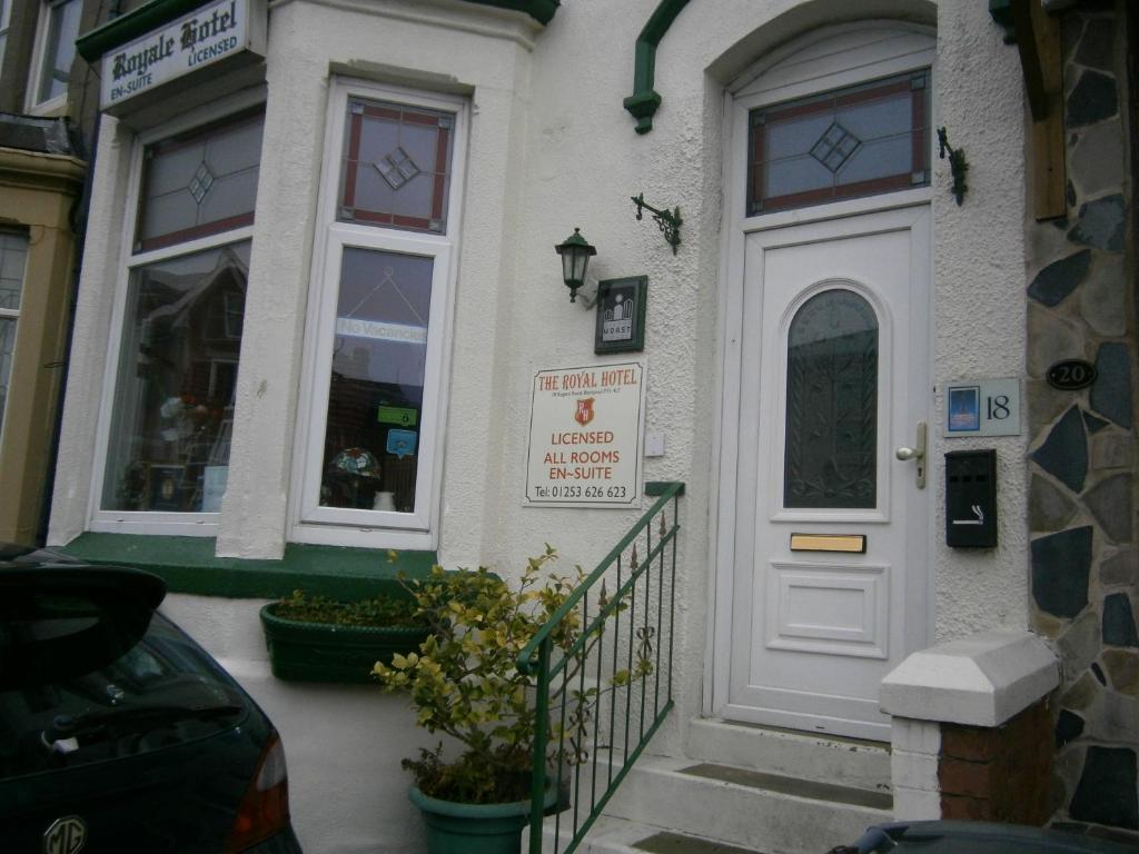 a building with a white door and a sign on it at Guesthouse The Royale Hotel in Blackpool