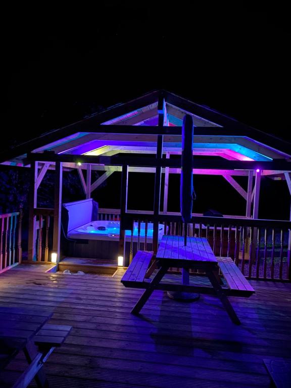 a wooden bench sitting on a deck at night at Balintombuie in Dalchreichart