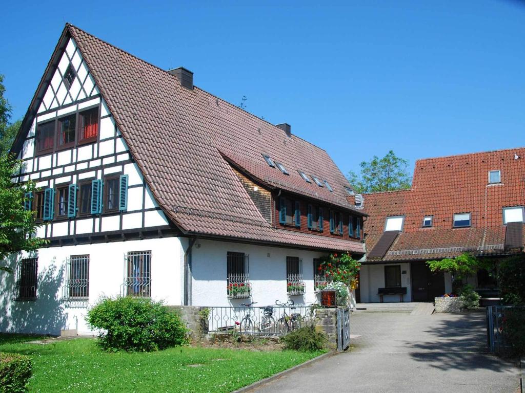ein großes weißes Gebäude mit braunem Dach in der Unterkunft Don-Bosco-Haus in Friedrichshafen