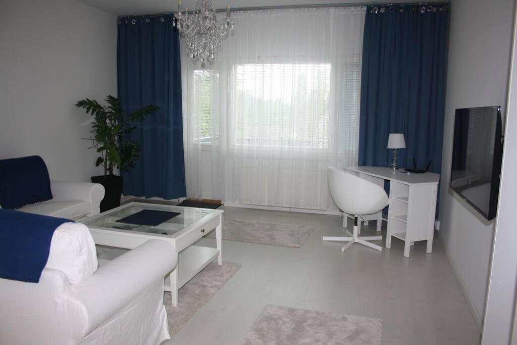 a living room with a couch and a table and a desk at BlueSolarPearl B - vaihtoehto majoittumiselle in Linnavuori
