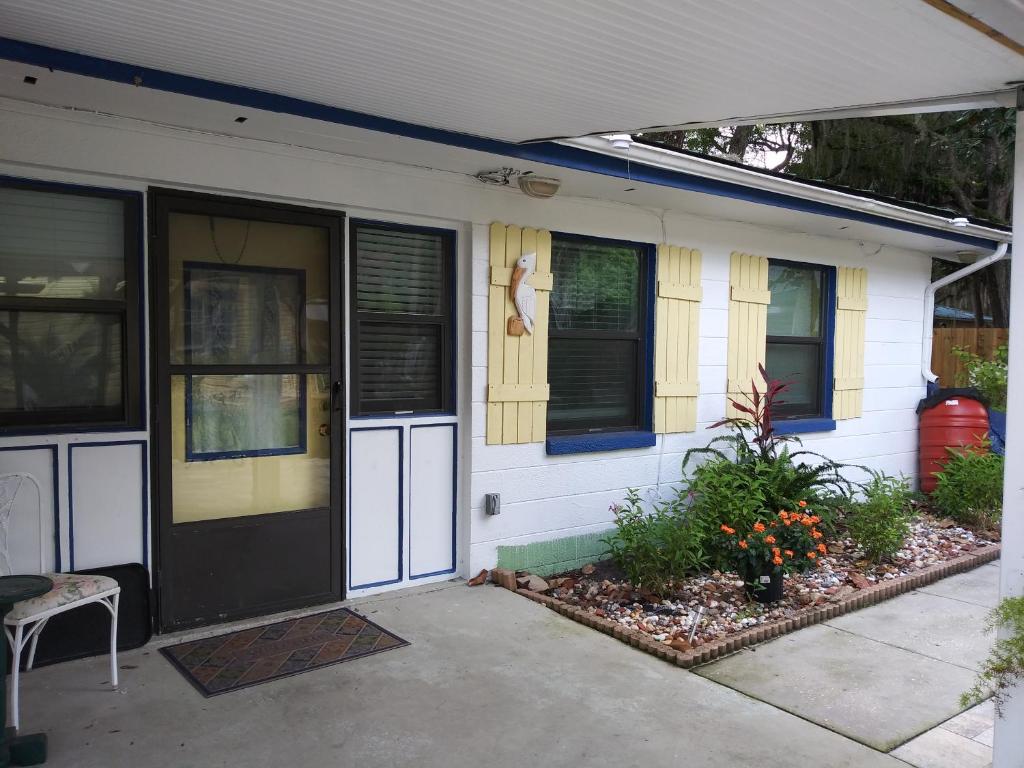 a white house with a black door and windows at The Three Sisters - Crystal River FL in Crystal River