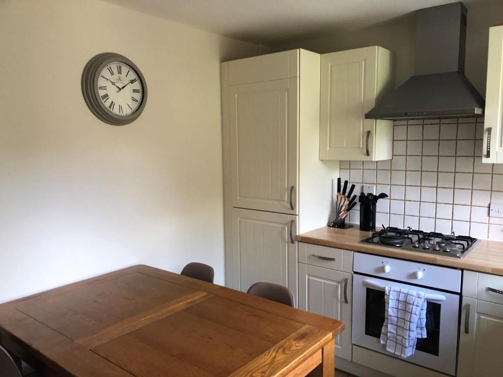 a kitchen with a table and a clock on the wall at Springfield in Oakham