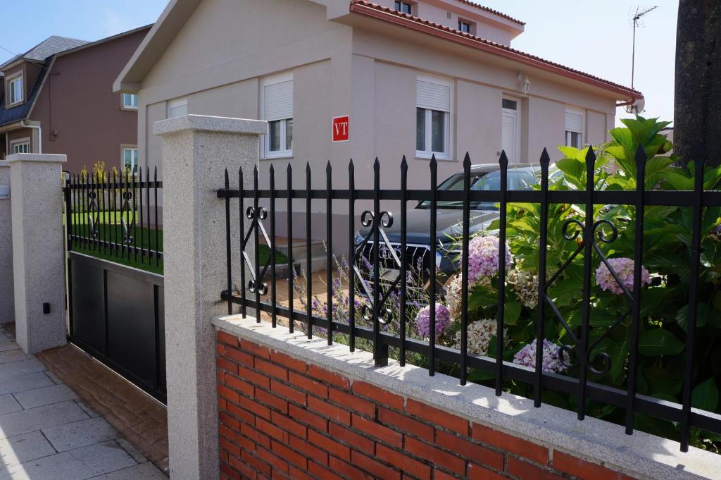 einen schwarzen schmiedeeisernen Zaun vor einem Haus in der Unterkunft Casa Asientos Boimorto in Boimorto