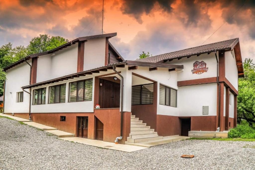 un gran edificio blanco y marrón con un cielo en el fondo en Hățașul Bunicului en Arefu