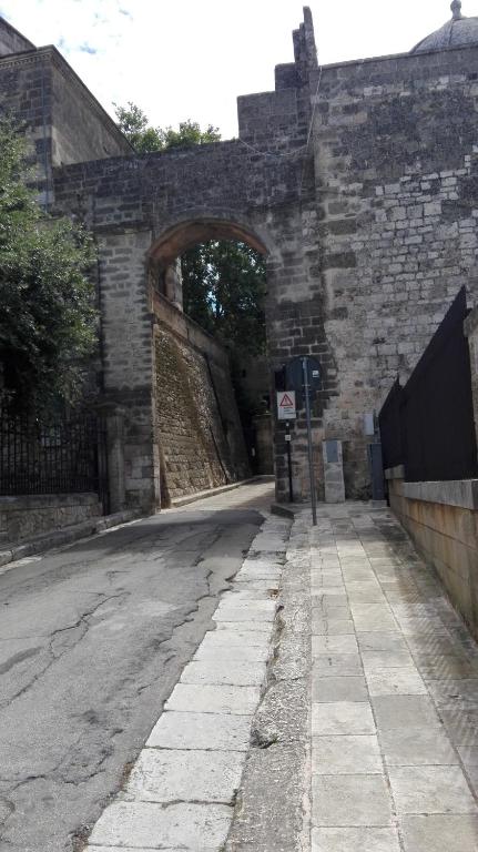 an old stone building with an archway on a street at B&B CASAVACANZE CHIESA MADRE in Carovigno