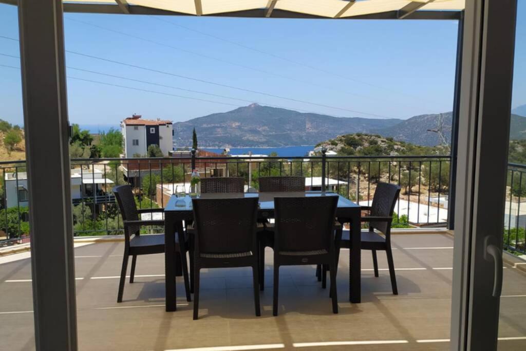 a table and chairs on a balcony with a view at muda apart kalkan in Kalkan