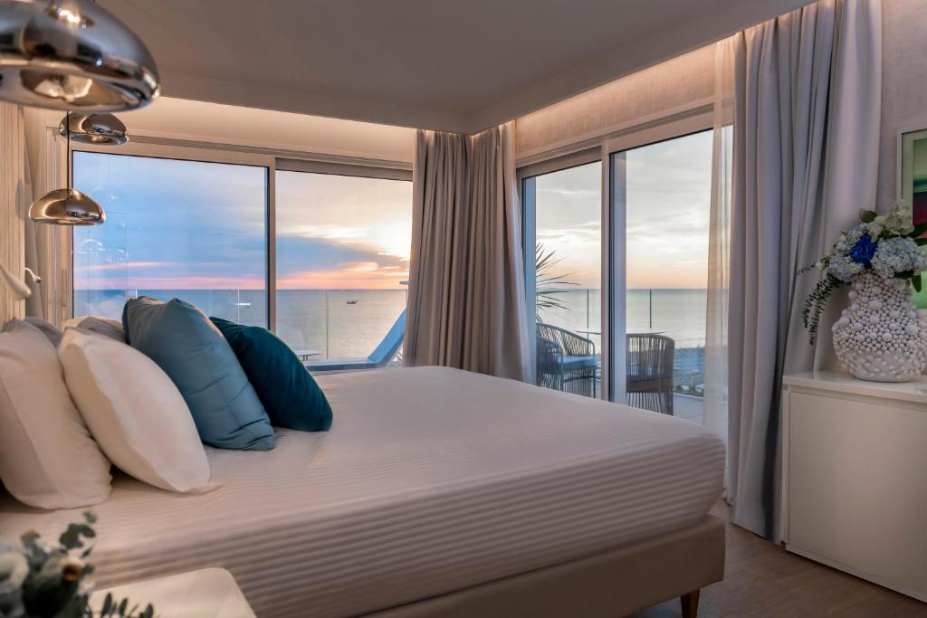 a bedroom with a bed with a view of the ocean at Hotel Atlantic in Riccione