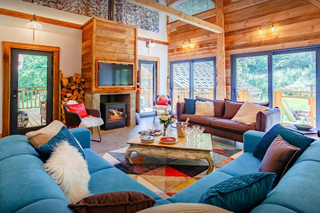 uma sala de estar com um sofá azul e uma lareira em Chalet Vivaldaim - OVO Network em La Rivière-Enverse