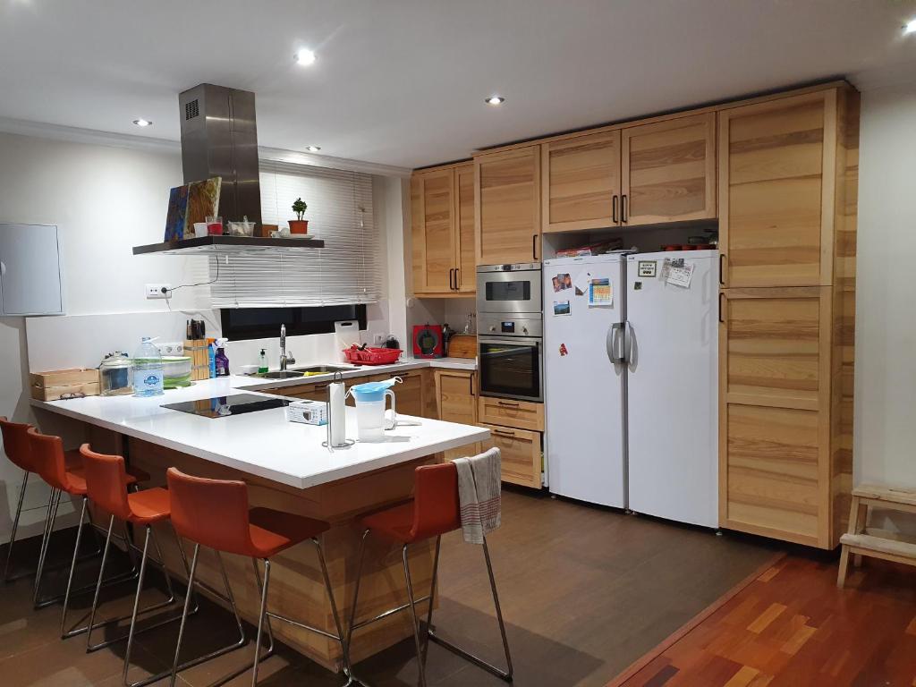 a kitchen with a white refrigerator and wooden cabinets at Alcaravaneras Home in Las Palmas de Gran Canaria