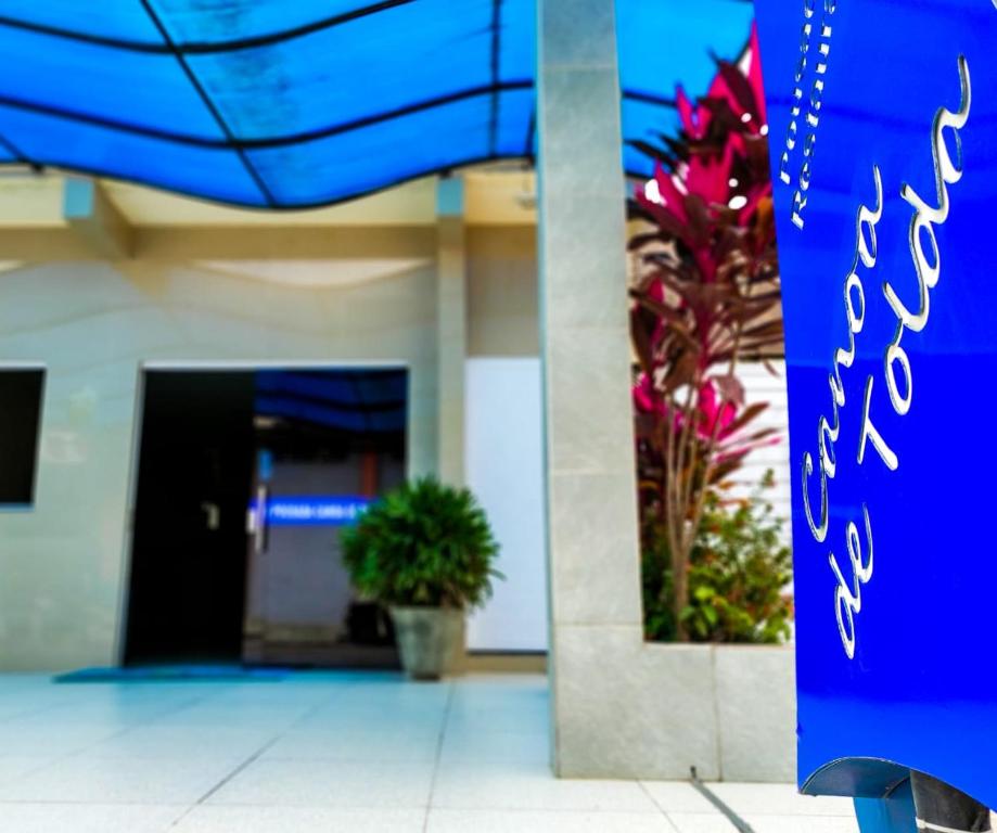 a blue sign in front of a building with flowers at Pousada Canoa de Tolda in Piranhas