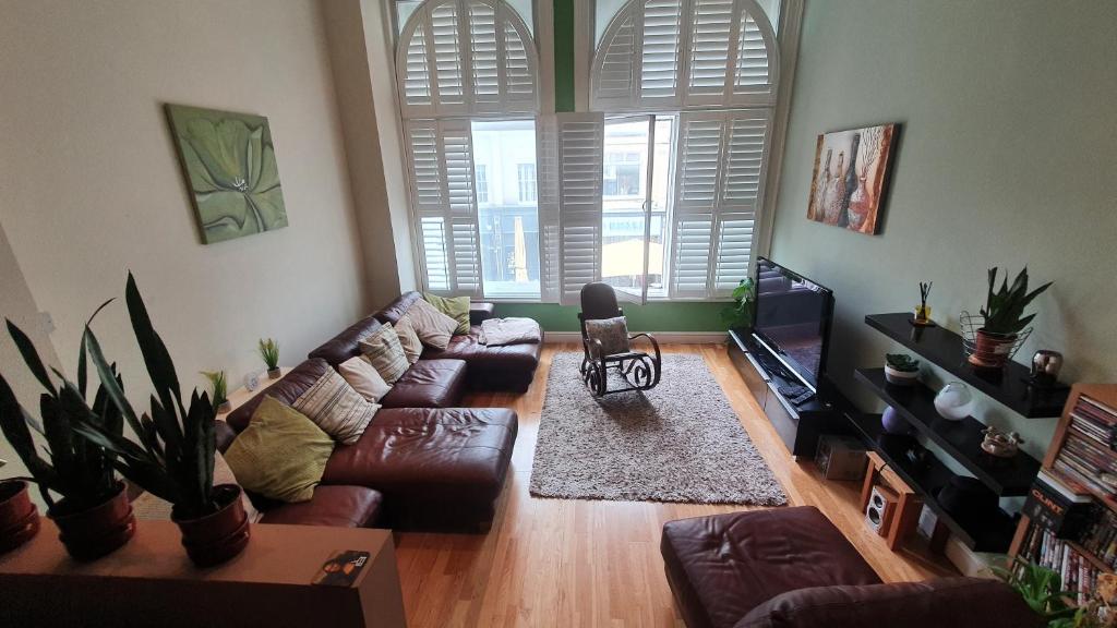 uma sala de estar com um sofá e uma televisão em Castell Haven Studio em Cardiff