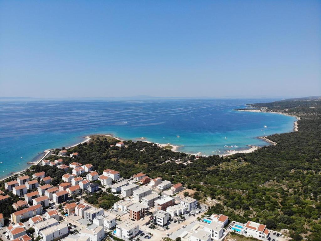 una vista aérea de una playa con casas y el océano en Apartman Valkira en Novalja