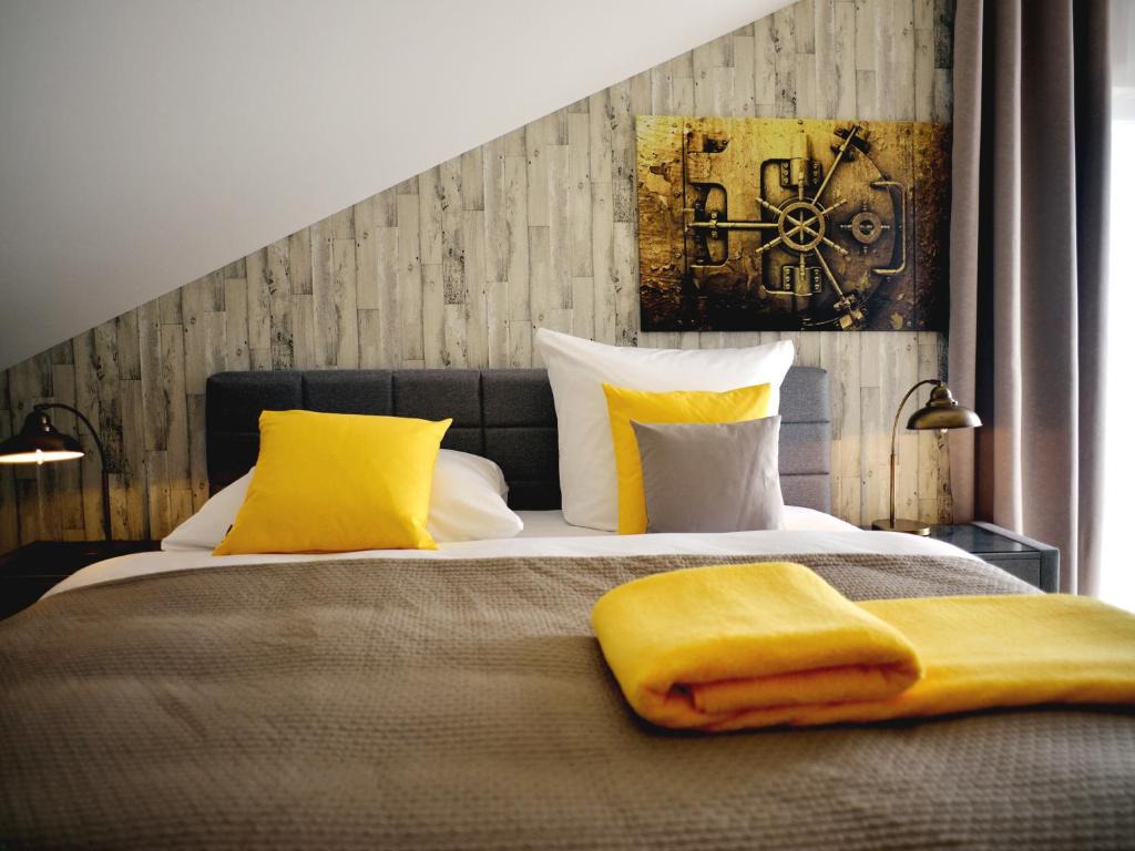 فندق آر آند جيه في روست: غرفة نوم بسرير مع مخدات صفراء