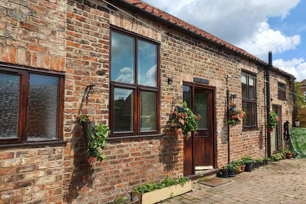 a brick building with windows and plants on it at Never to be booked in York