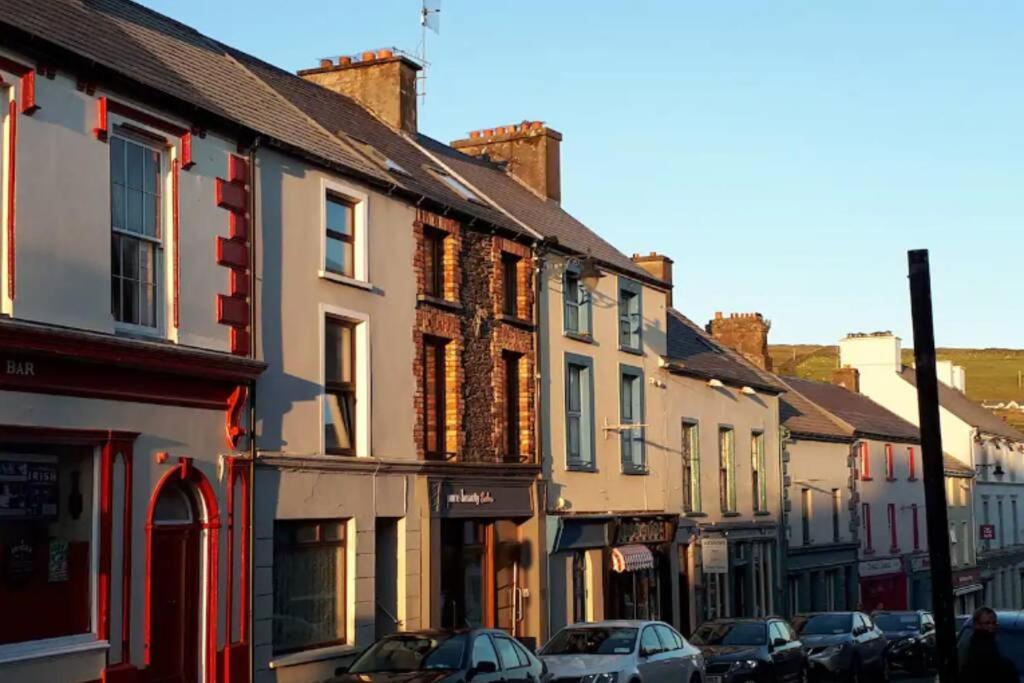 a row of buildings on a street with parked cars at Centre of Dingle Town - Luxury Holiday Apartment in Dingle