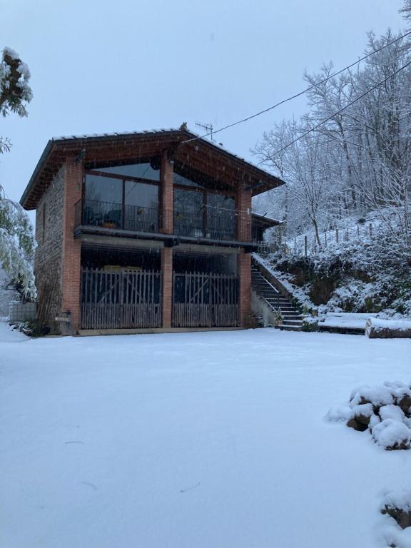 uma casa com varanda na neve em La Cabanya de Mas Gingi em Sant Joan les Fonts