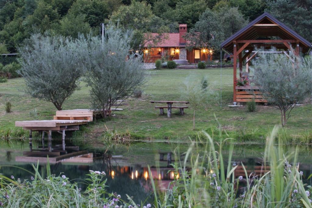 a log cabin with a picnic table and a pond at House Arupium in Otočac
