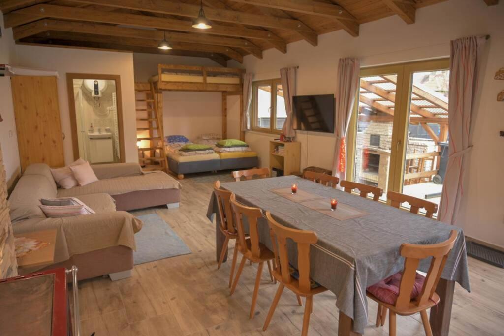 un soggiorno con un tavolo e un divano di Útulný domek v zahradě v Unhošti nedaleko letiště a Unhošť