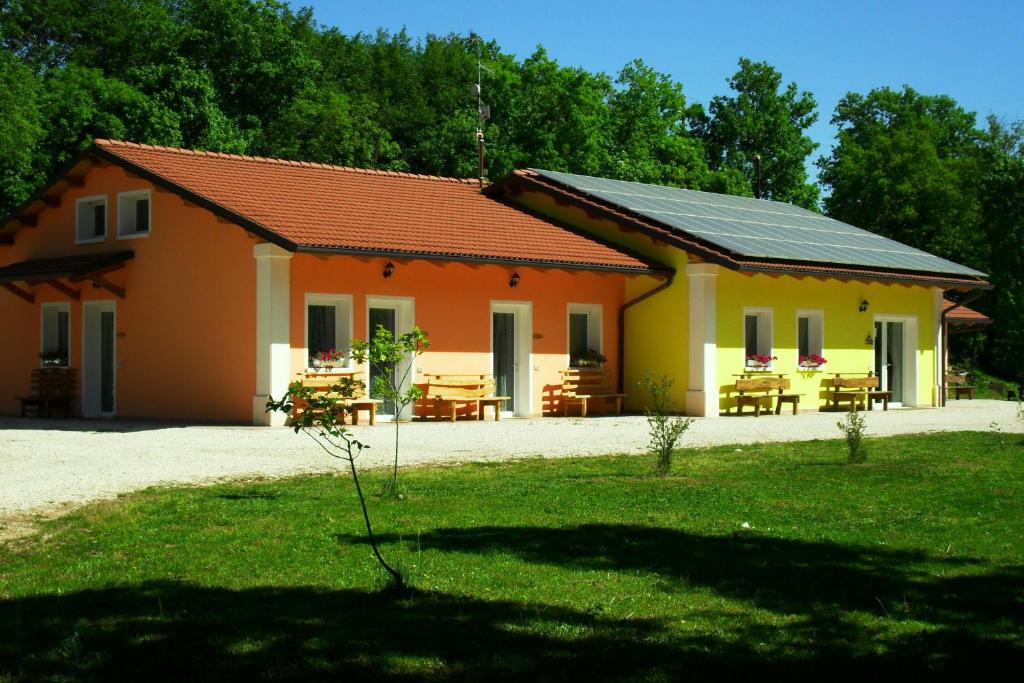 una casa gialla e arancione con tavolo da picnic di Alle Vallesse ad Altavilla Vicentina