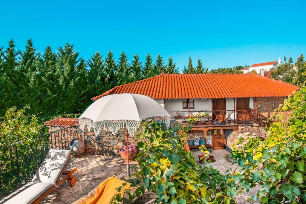 a house with an umbrella in front of it at Villa Dos Cedros in Pereira