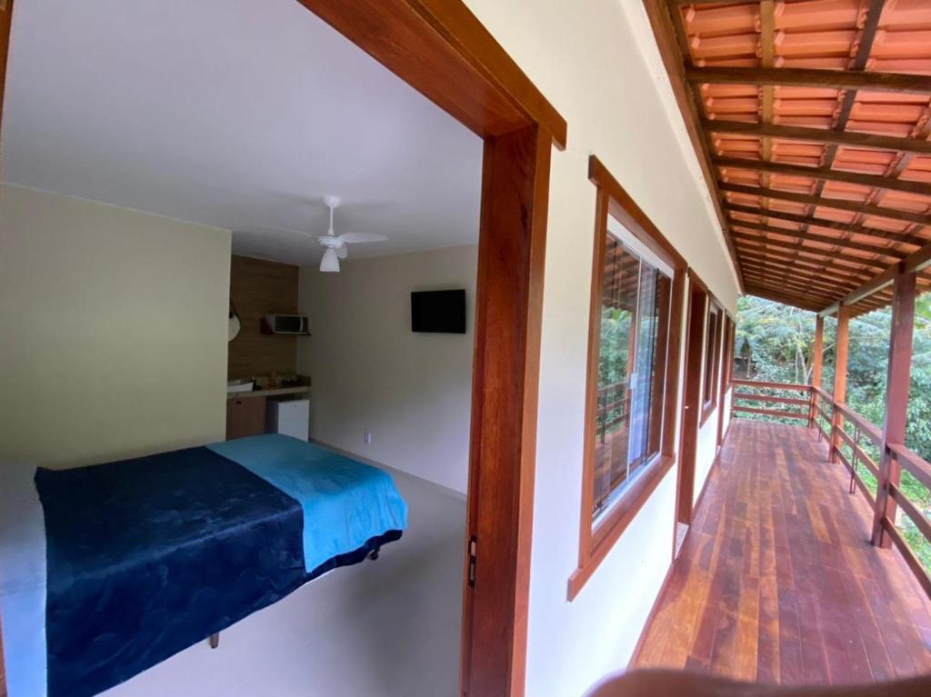 a bedroom with a bed and a balcony at Espaço Beira Rio in Nova Friburgo