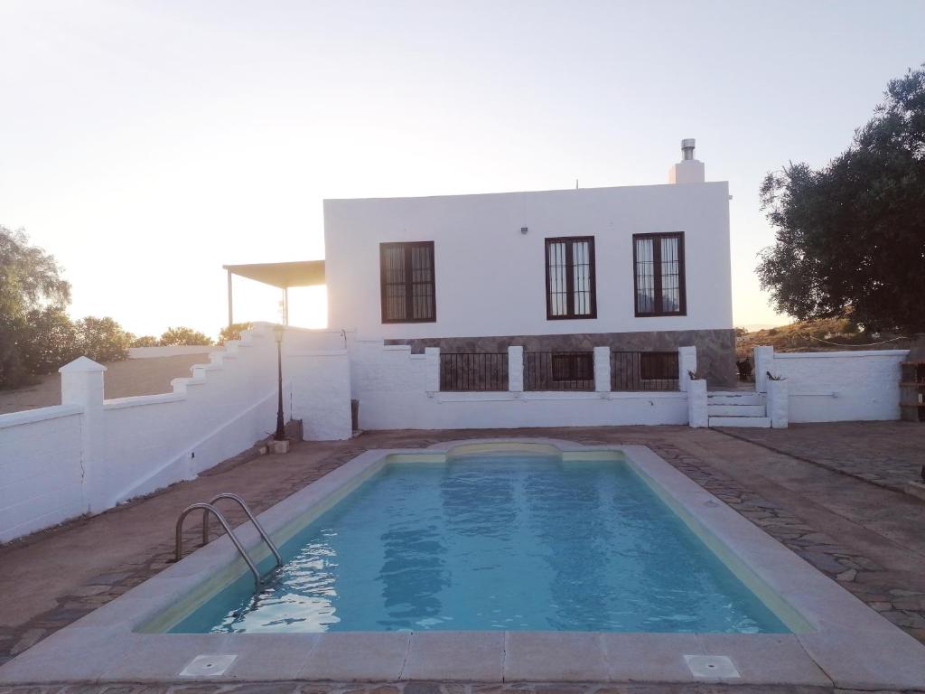 una casa con piscina frente a ella en Cortijo El Aire, Parque Natural Cabo de Gata, en El Pozo de los Frailes