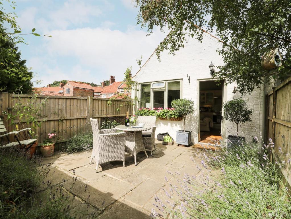 a backyard with a table and chairs and a fence at The Old Forge in Stillington