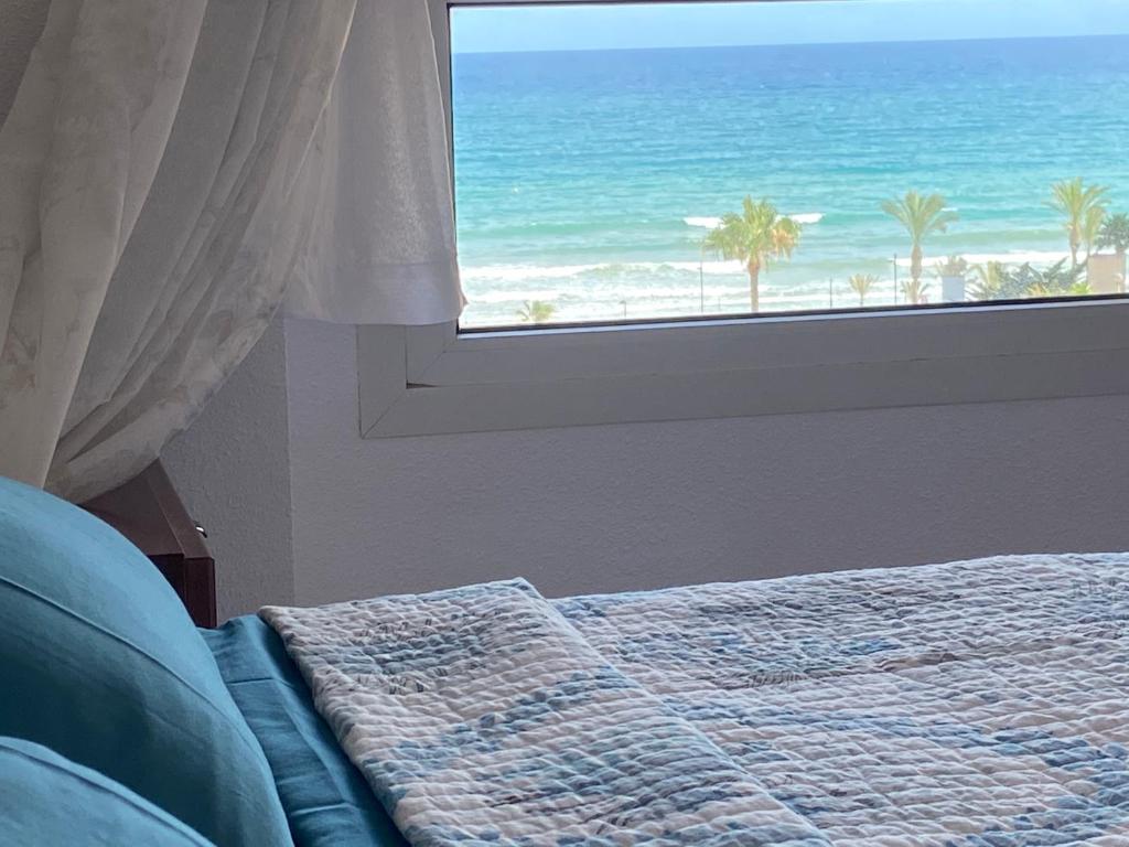 sypialnia z łóżkiem i widokiem na ocean w obiekcie Alicante Apartamento en la Playa Muchavista-San Juan - Marluma frente al Mar w mieście La Venteta