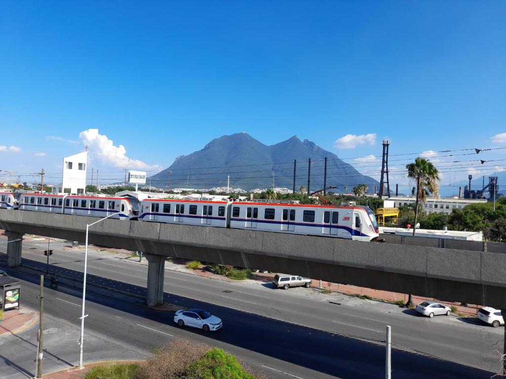 un tren en un puente sobre una autopista en Special HOEStel in Monterrey!, en Monterrey