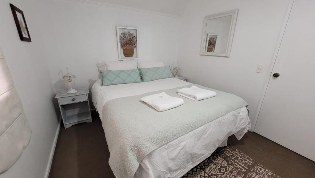 ein Schlafzimmer mit einem Bett mit zwei Handtüchern darauf in der Unterkunft Prairie's House in Temuco