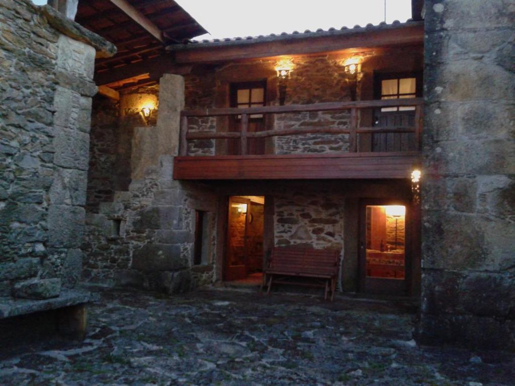 a building with a balcony and a bench in front of it at Casa do Pontelhão Serra d'Arga in Arga de Cima