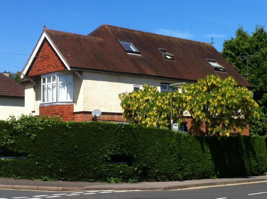 una casa con un seto delante de ella en Pound Corner, en Godalming