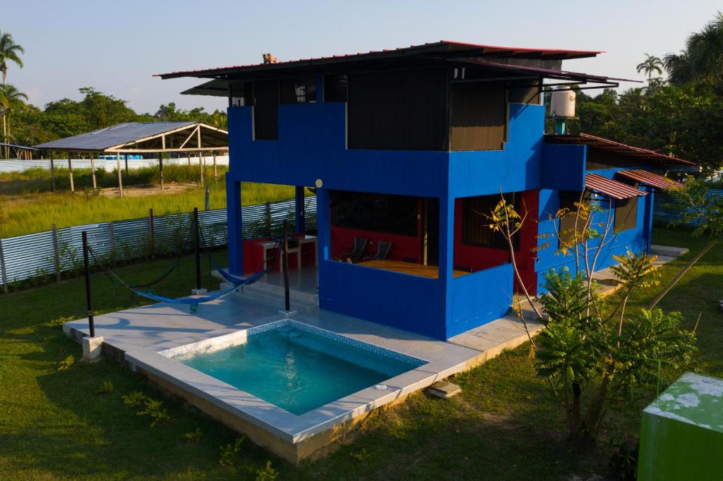 una casa azul con piscina en un patio en Guacamayo Azul en Iquitos