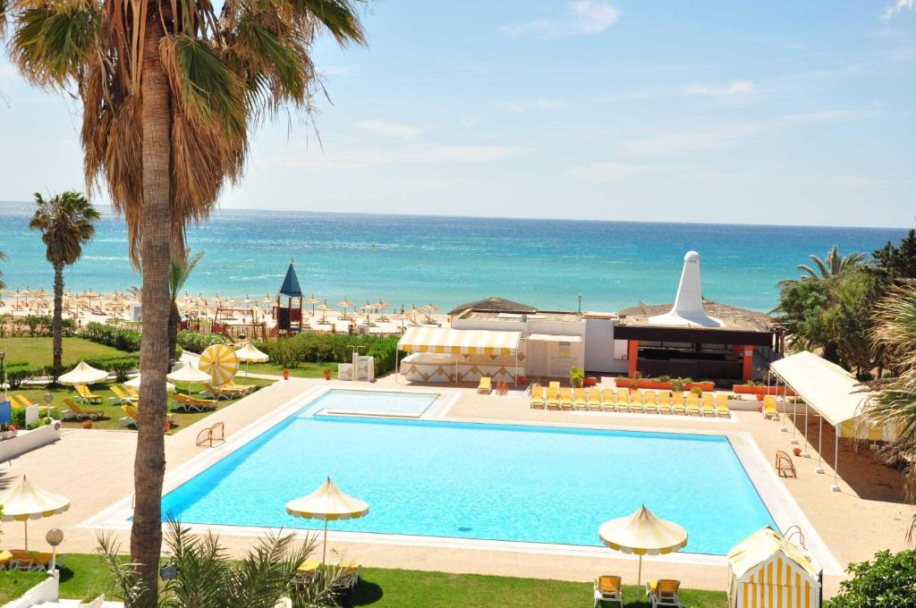 a swimming pool with the ocean in the background at Hotel El Fell in Hammamet