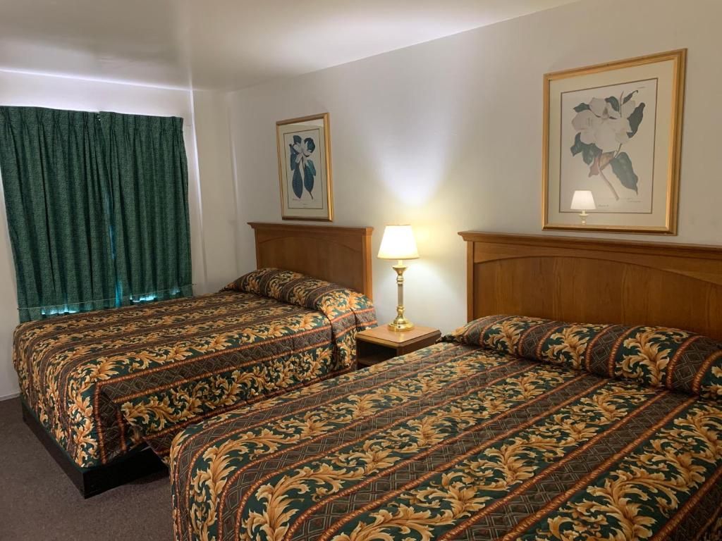a hotel room with two beds and a window at Economy Inn Kingman in Kingman