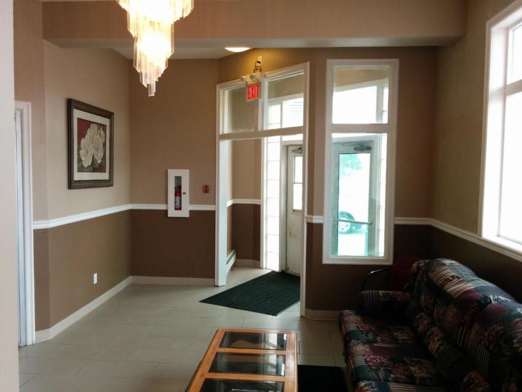 a living room with a couch and a chandelier at Bonnyville Hotel in Bonnyville