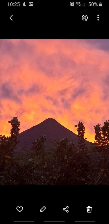 a mountain with a sunset in the background at Apartamento La Fortuna #2 in Fortuna