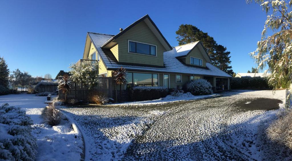 a house in the snow with a driveway at Manuka Lodge B&B in Ohakune