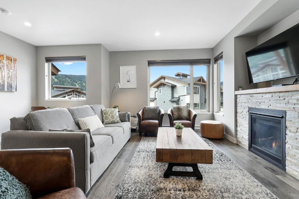 a living room with a couch and a fireplace at Spacious Modern Ski-in Ski-out with Hot Tub Townhouse in Sun Peaks