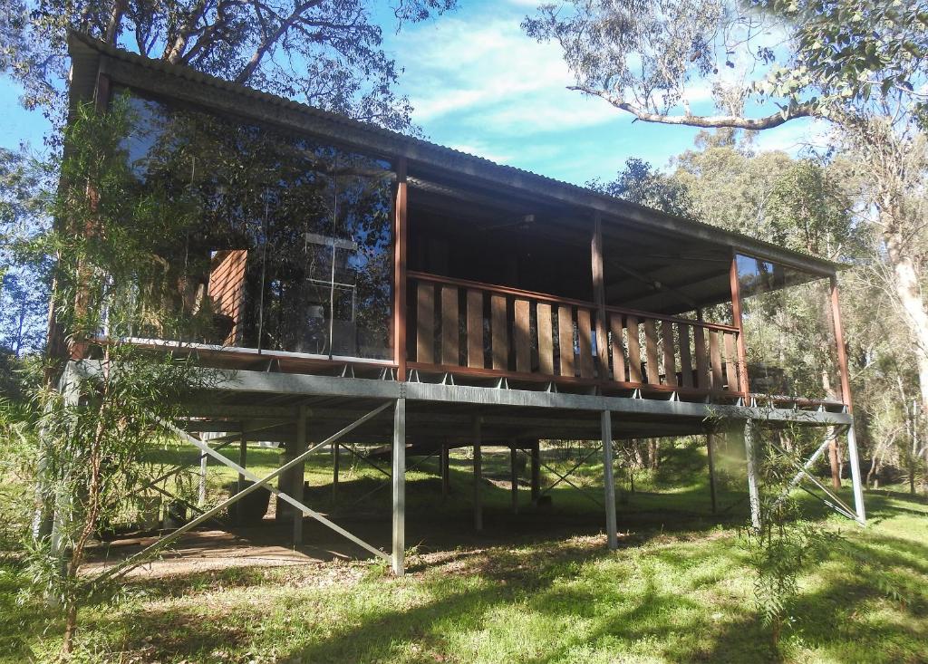 a house that is sitting in the grass at Barrabup Sanctuary BirdHide in Nannup